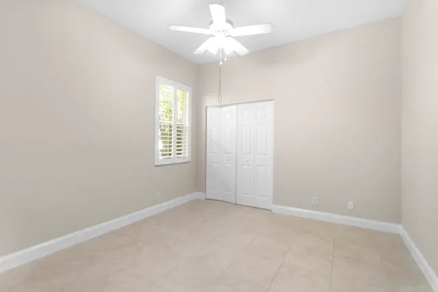 an empty room with a window and a fan