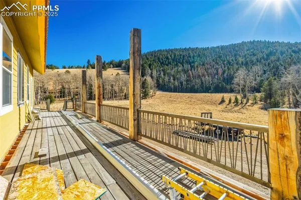 a view of a balcony with wooden floor and fence