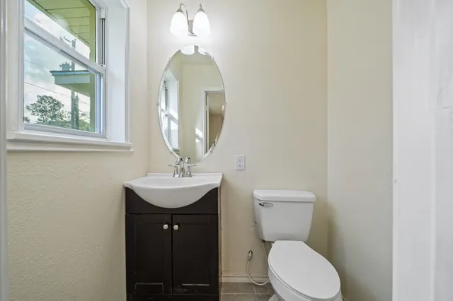 a bathroom with a toilet a sink and mirror