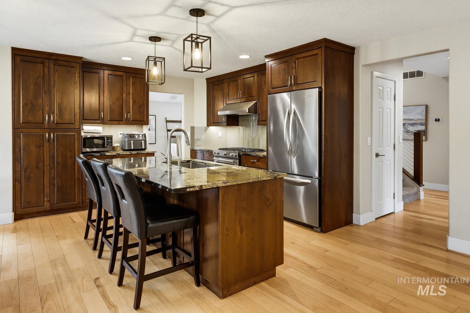 369 South Winthrop Way Boise, ID 83709 - Photo 14 of 50 Kitchen featuring a central island with a multi-toned countertop, stainless steel sink, and gooseneck faucet