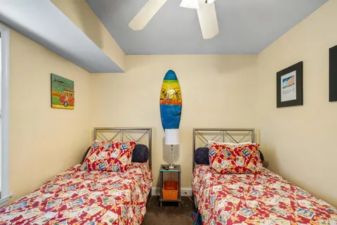 a bedroom with two beds and painting on the wall