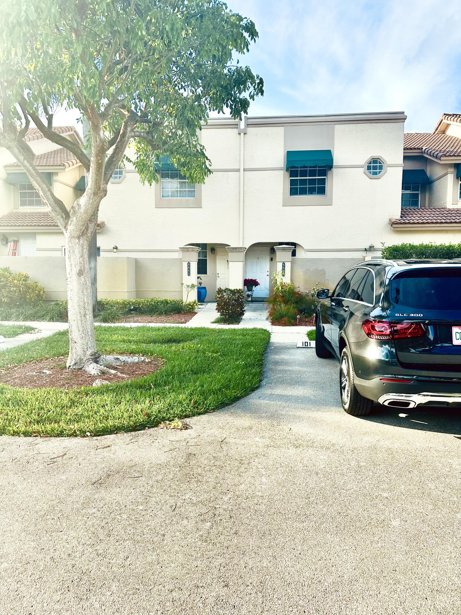 6663 Via Regina Boca Raton, FL 33433 - Photo 2 of 16 a car parked in front of a house and a yard