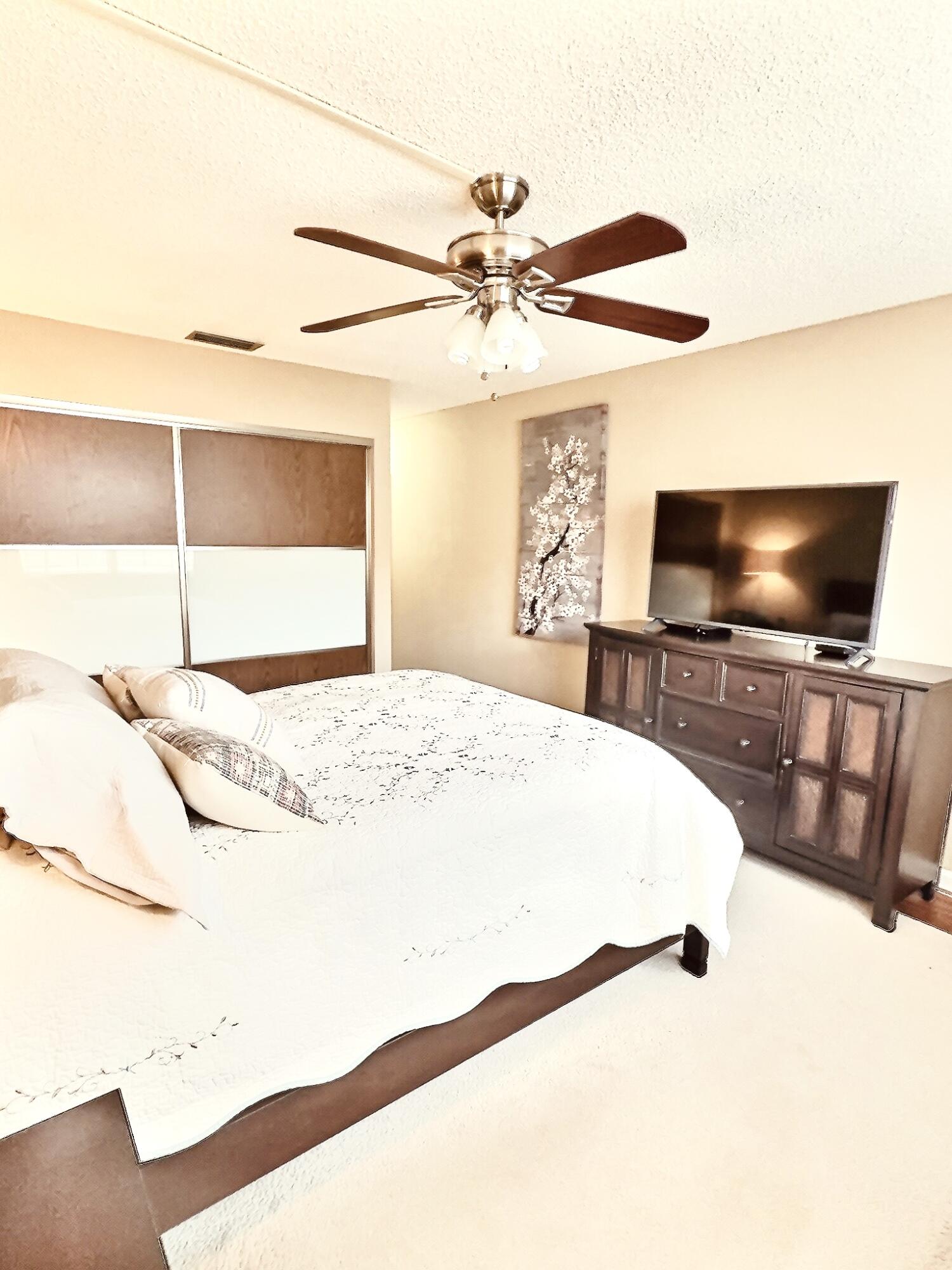 6663 Via Regina Boca Raton, FL 33433 - Photo 5 of 16 a bedroom with a bed and a flat screen tv