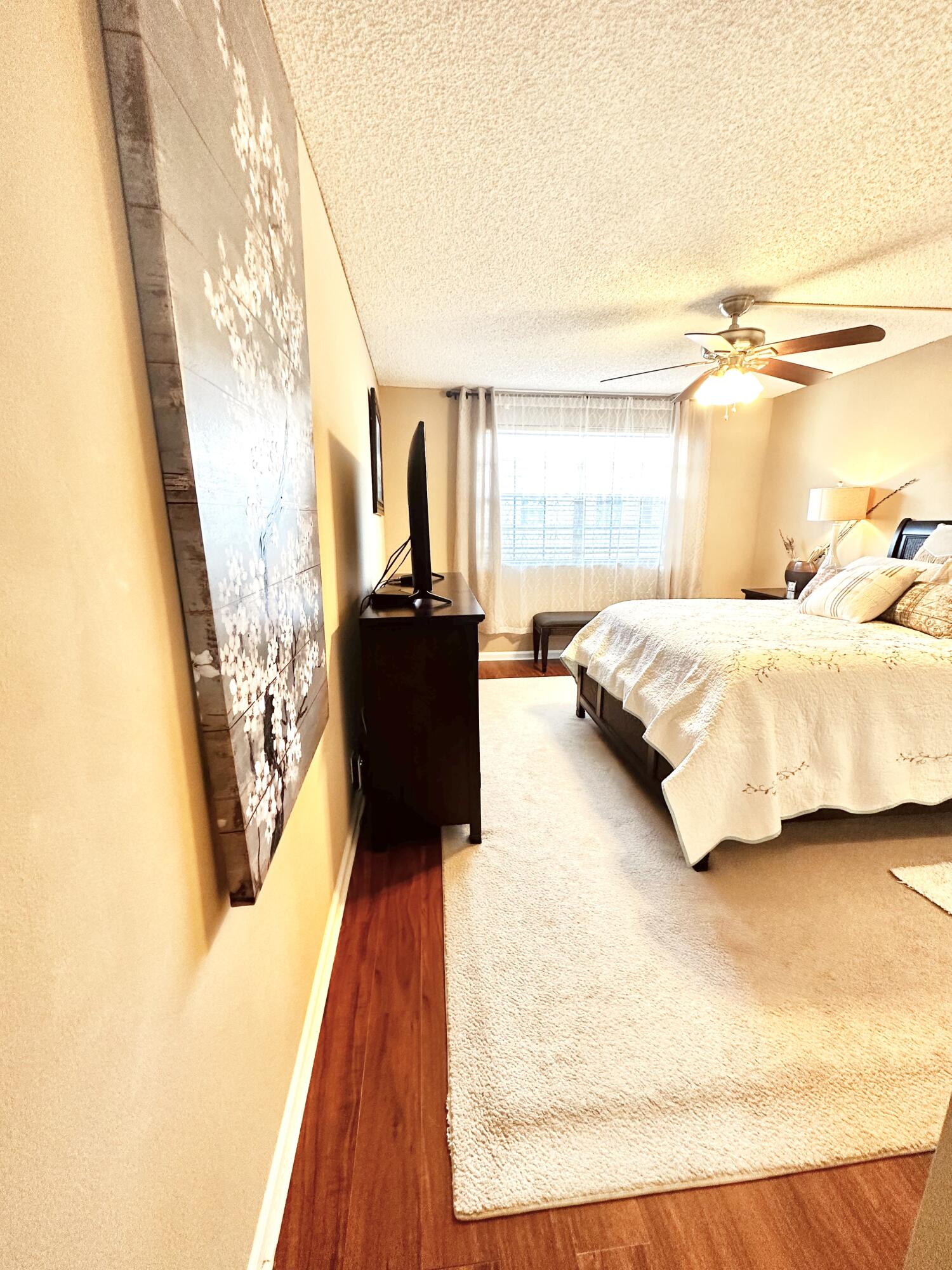 6663 Via Regina Boca Raton, FL 33433 - Photo 6 of 16 a spacious bedroom with a bed and wooden floor