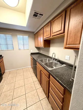 a kitchen with a sink a stove cabinets and a window