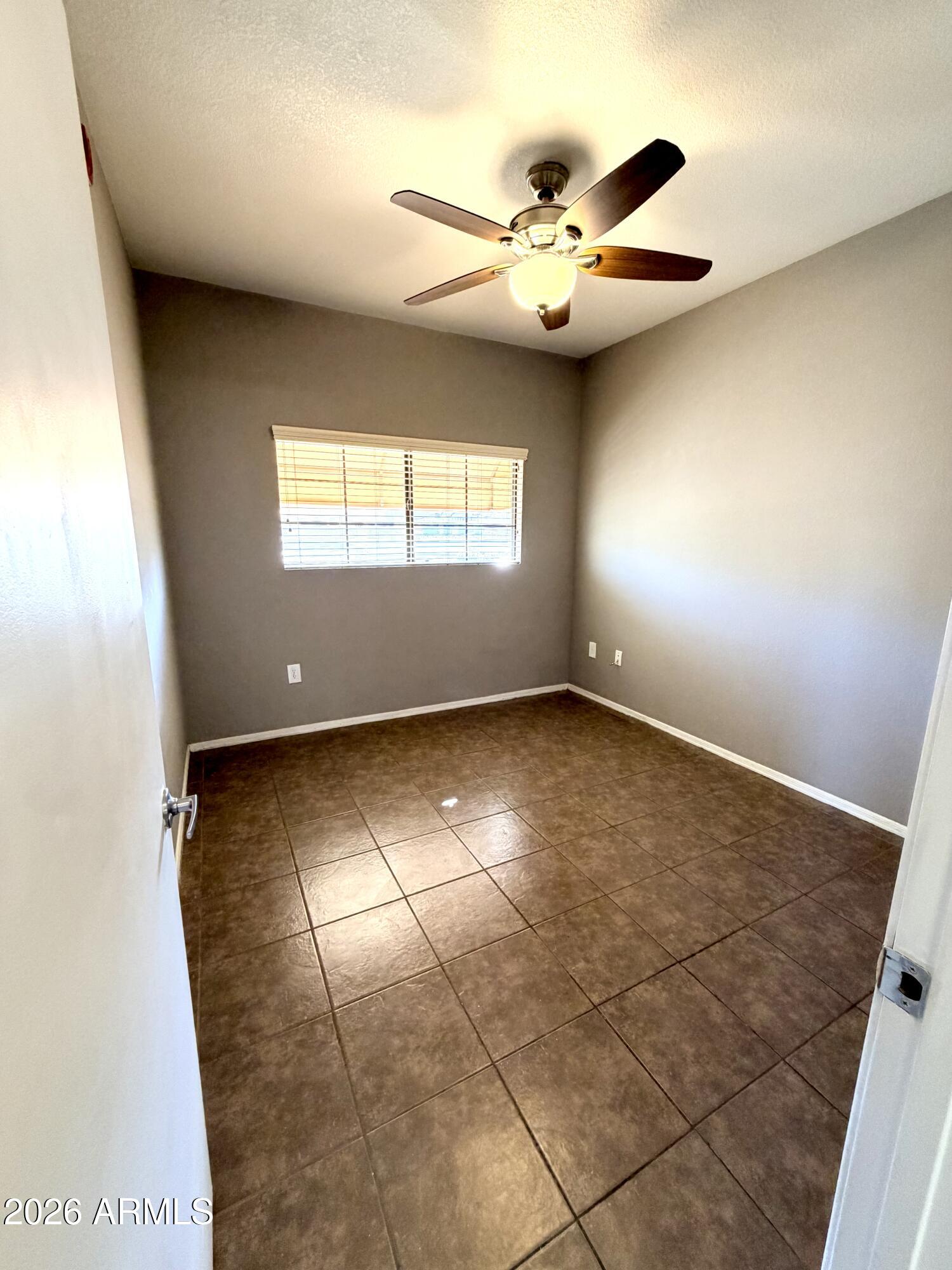 3434 East Baseline Road, Unit 165 Phoenix, AZ 85042 - Photo 9 of 12 an empty room with windows and ceiling fan