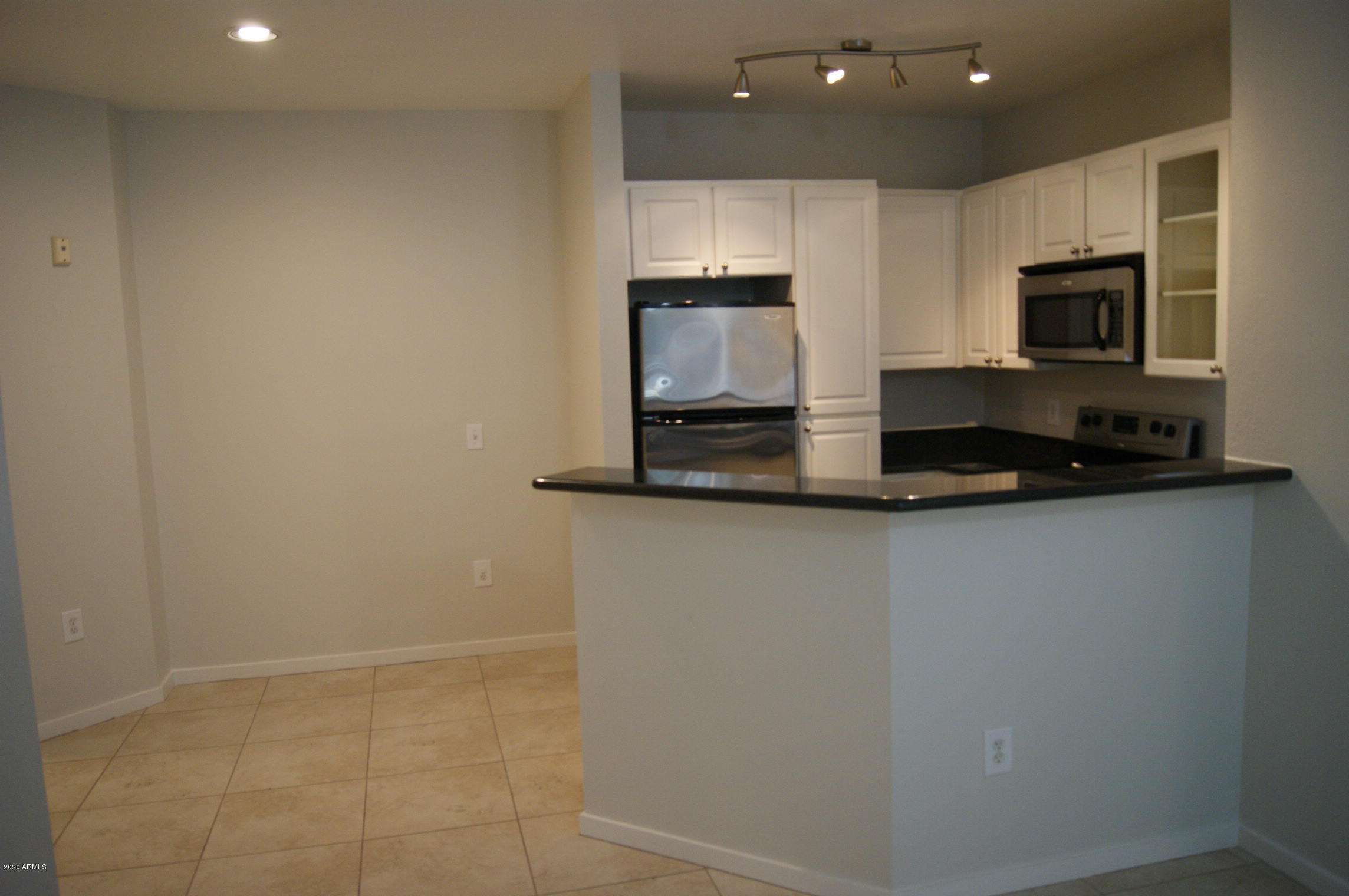 3633 North 3rd Avenue, Unit 1060 Phoenix, AZ 85013 - Photo 11 of 23 a kitchen with kitchen island white cabinets and stainless steel appliances
