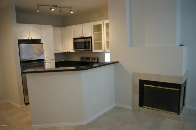 a kitchen with granite countertop white cabinets and stainless steel appliances