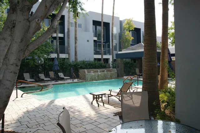 a view of a patio with table and chairs potted plants and a fountain