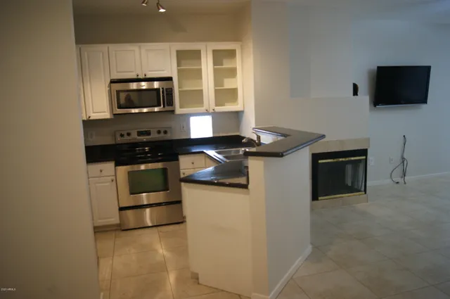 a kitchen with stainless steel appliances a stove microwave and sink