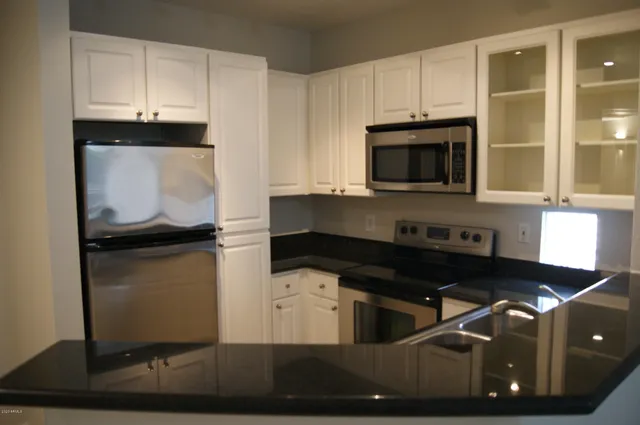 a kitchen with granite countertop a stove and a microwave