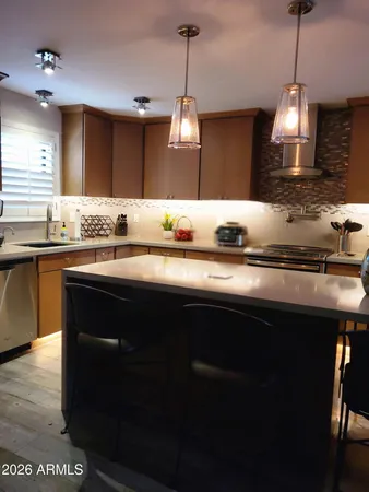 a kitchen with kitchen island granite countertop a sink stainless steel appliances and cabinets