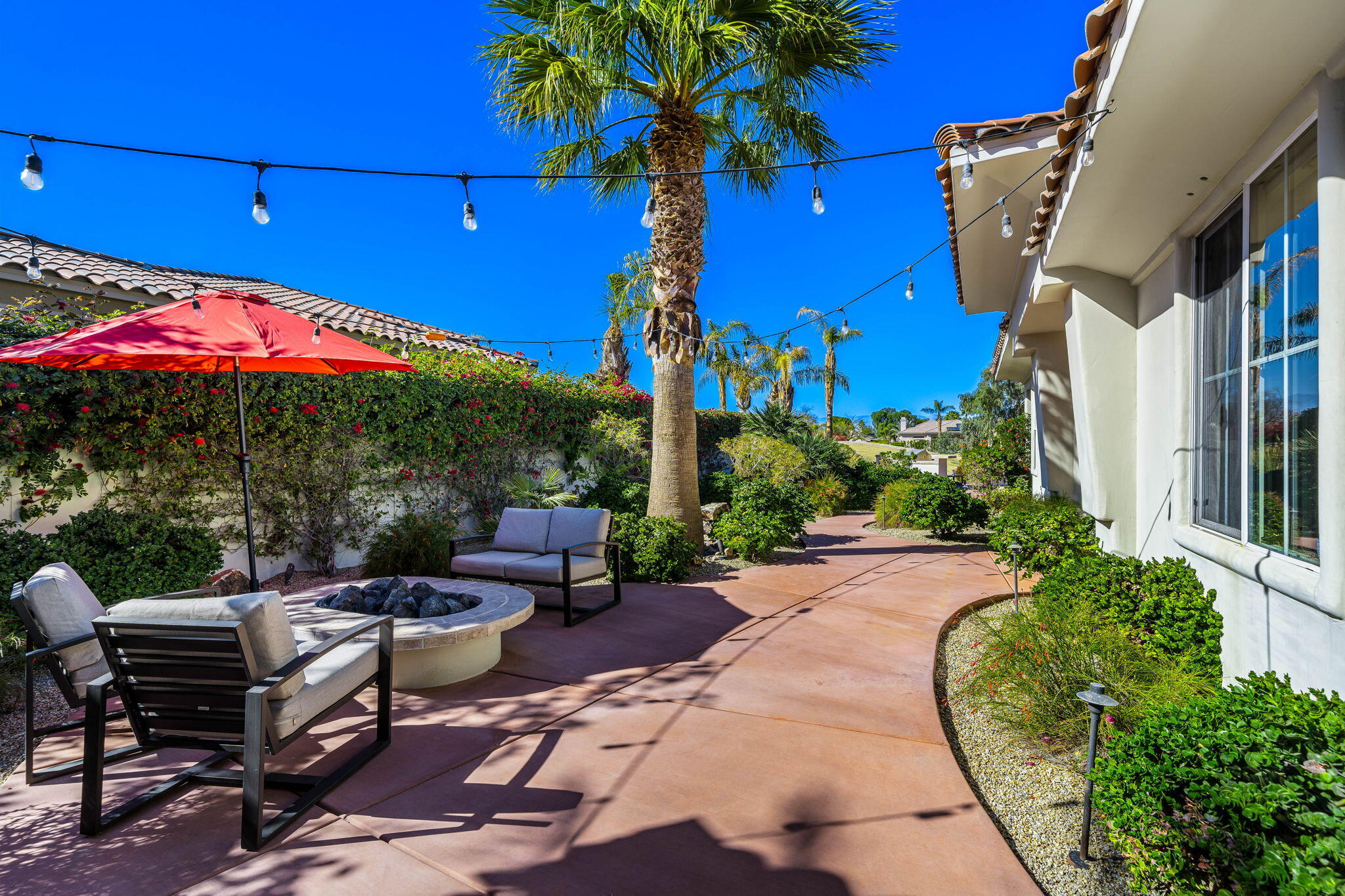 309 Loch Lomond Road Rancho Mirage, CA 92270 - Photo 20 of 27 a view of a patio with couches and table and chairs under an umbrella