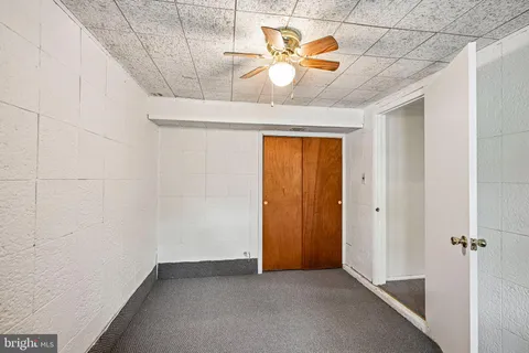 an empty room with a window and chandelier