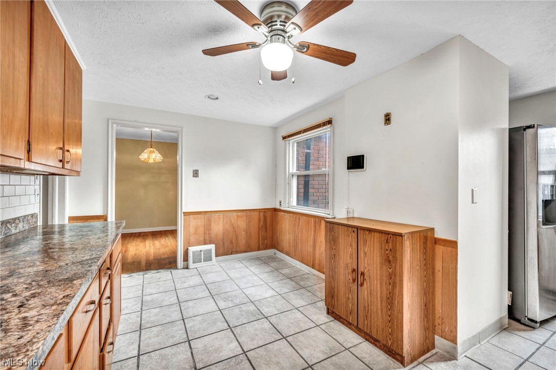 3946 Lansdale Road Cleveland, OH 44118 - Photo 13 of 42 Kitchen with light tile floors, stainless steel fridge with ice dispenser, a textured ceiling, hanging light fixtures, and ceiling fan