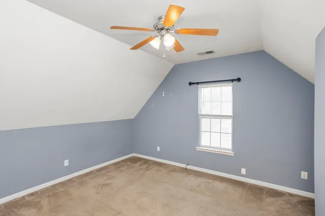 an empty room with closet and a ceiling fan