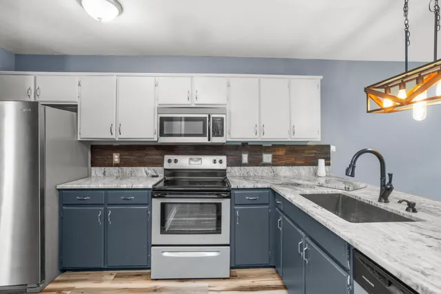 a view of an empty room with wooden floor fireplace and a window
