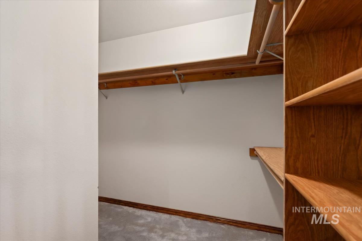 8275 Washoe Road Fruitland, ID 83619 - Photo 19 of 43 Walk-in closet featuring built-in shelving, wood-finish hanging rods, and light gray carpeting