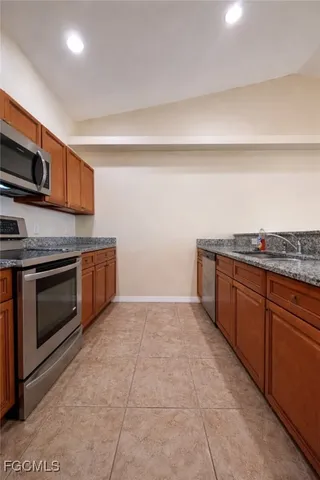 a kitchen with stainless steel appliances granite countertop a stove a sink and a microwave