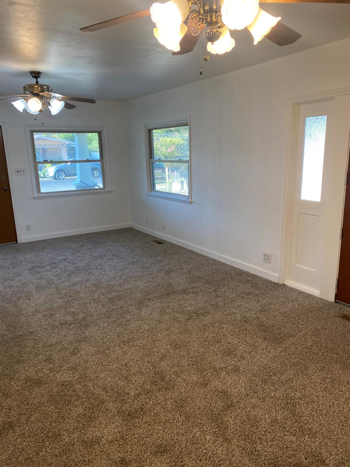 947 West Friesen Avenue Reedley, CA 93654 - Photo 12 of 34 en empty room with chandelier fan and windows