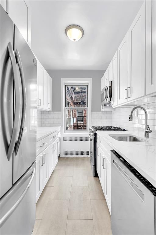 9281 Shore Road, Unit 602 Brooklyn, NY 11209 - Photo 7 of 17 a kitchen with granite countertop a sink stove and cabinets