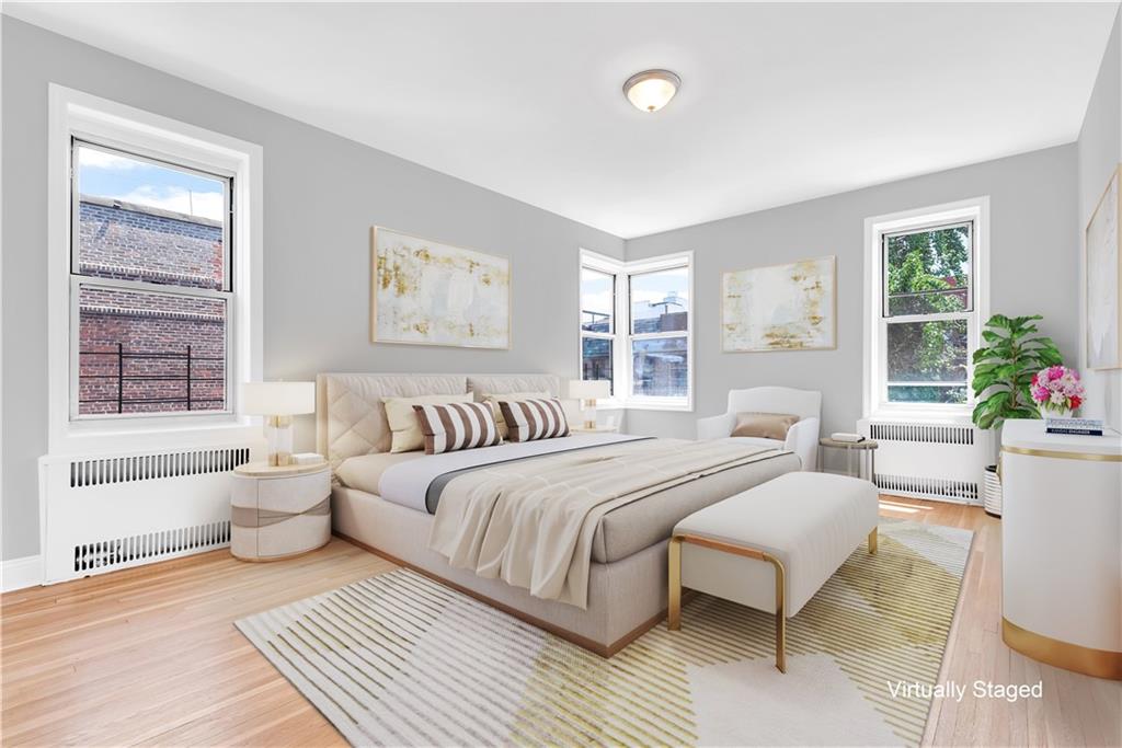 9281 Shore Road, Unit 602 Brooklyn, NY 11209 - Photo 9 of 17 a spacious bedroom with a large bed a chandelier and windows