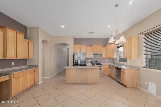 a kitchen with stainless steel appliances kitchen island granite countertop a sink and cabinets