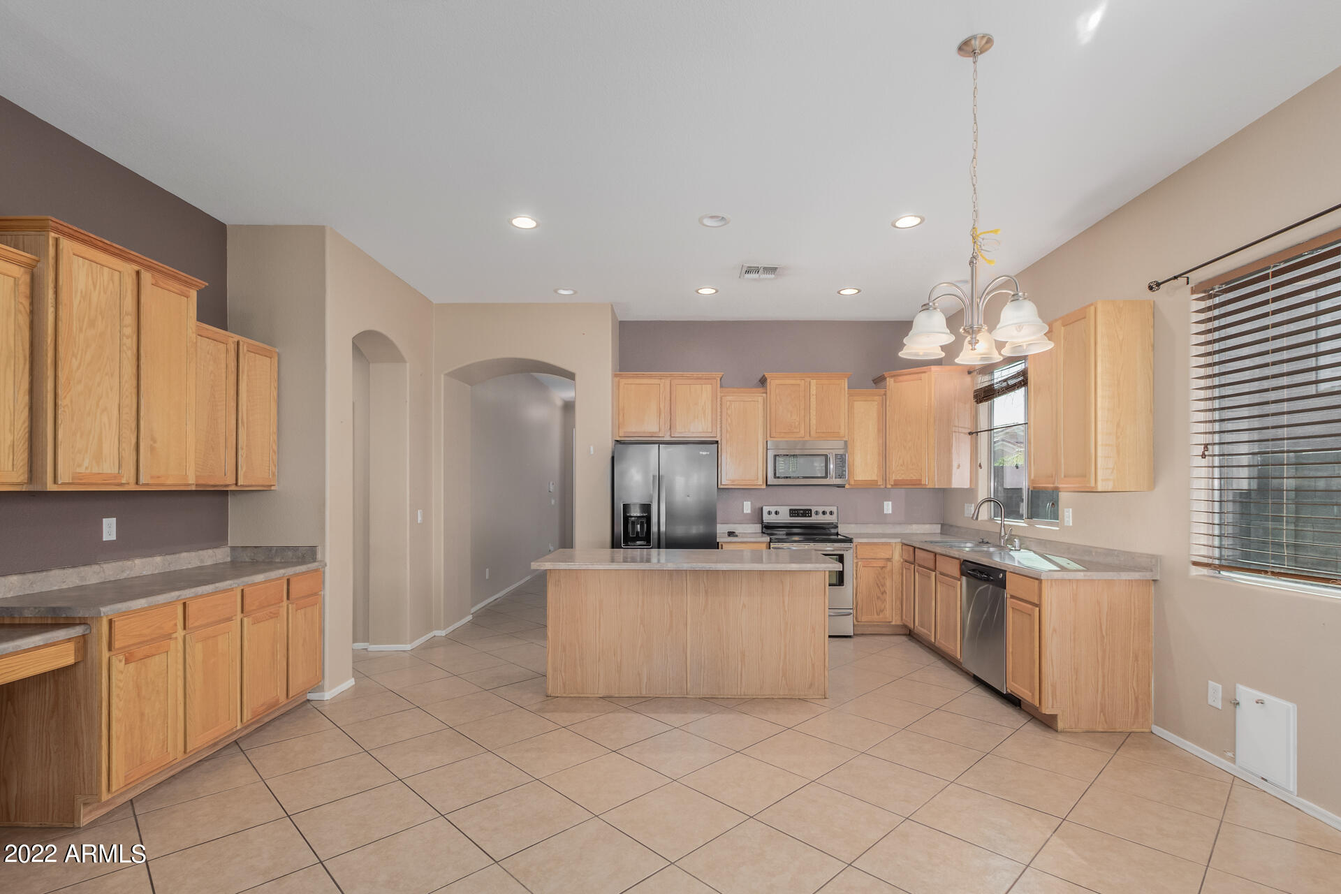 14440 West Redfield Road Surprise, AZ 85379 - Photo 13 of 36 a kitchen with stainless steel appliances kitchen island granite countertop a sink and cabinets