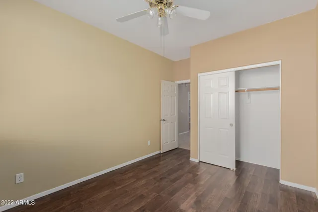 wooden floor in an empty room with a chandelier fan