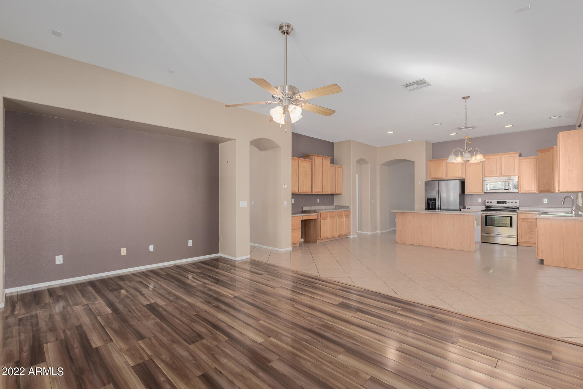 14440 West Redfield Road Surprise, AZ 85379 - Photo 27 of 36 a view of a kitchen with kitchen island wooden floor appliances and a ceiling fan