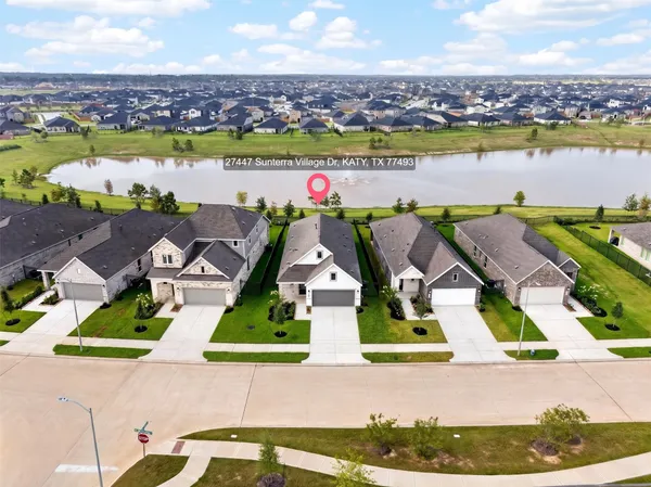 an aerial view of residential houses with outdoor space and lakeside