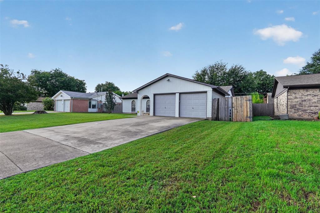 1212 Manning Road Benbrook, TX 76126 - Photo 2 of 20 Front exterior featuring a two-car garage, arched entry, and a concrete driveway