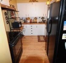 2636 Rountree Drive Abilene, TX 79601 - Photo 6 of 14 Kitchen featuring black appliances, light wood-style floors, white cabinetry, and wood counters