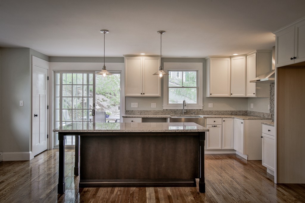 a kitchen with kitchen island granite countertop a sink window and refrigerator