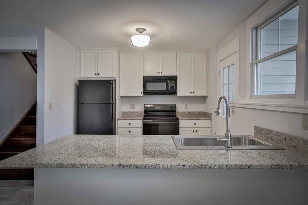 22 Marble Road Gloucester, MA 01930 - Photo 13 of 25 a kitchen with granite countertop a sink a refrigerator and a stove top oven