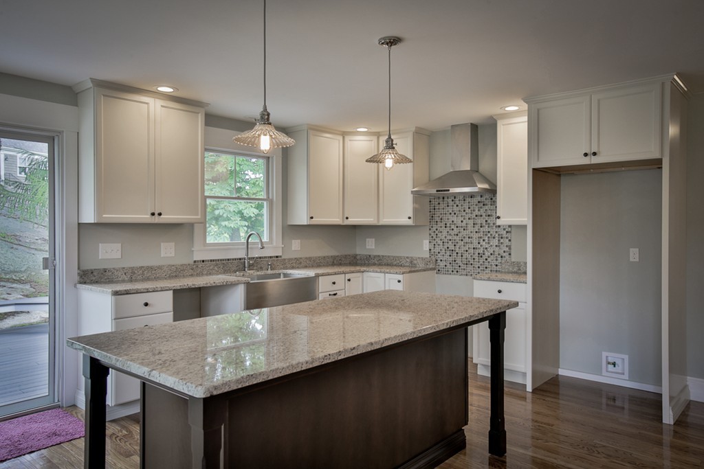 22 Marble Road Gloucester, MA 01930 - Photo 2 of 25 a kitchen with granite countertop a sink a center island a stove and a wooden floor