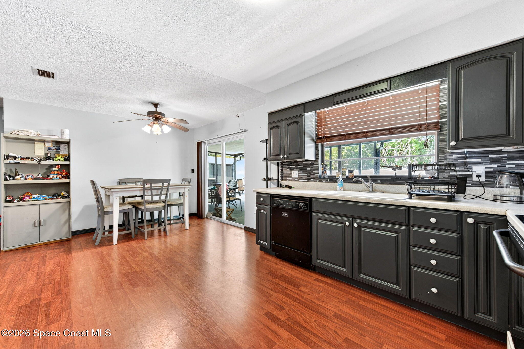 3300 Argyle Road Titusville, FL 32796 - Photo 8 of 29 a kitchen with stainless steel appliances granite countertop wooden floors and white cabinets