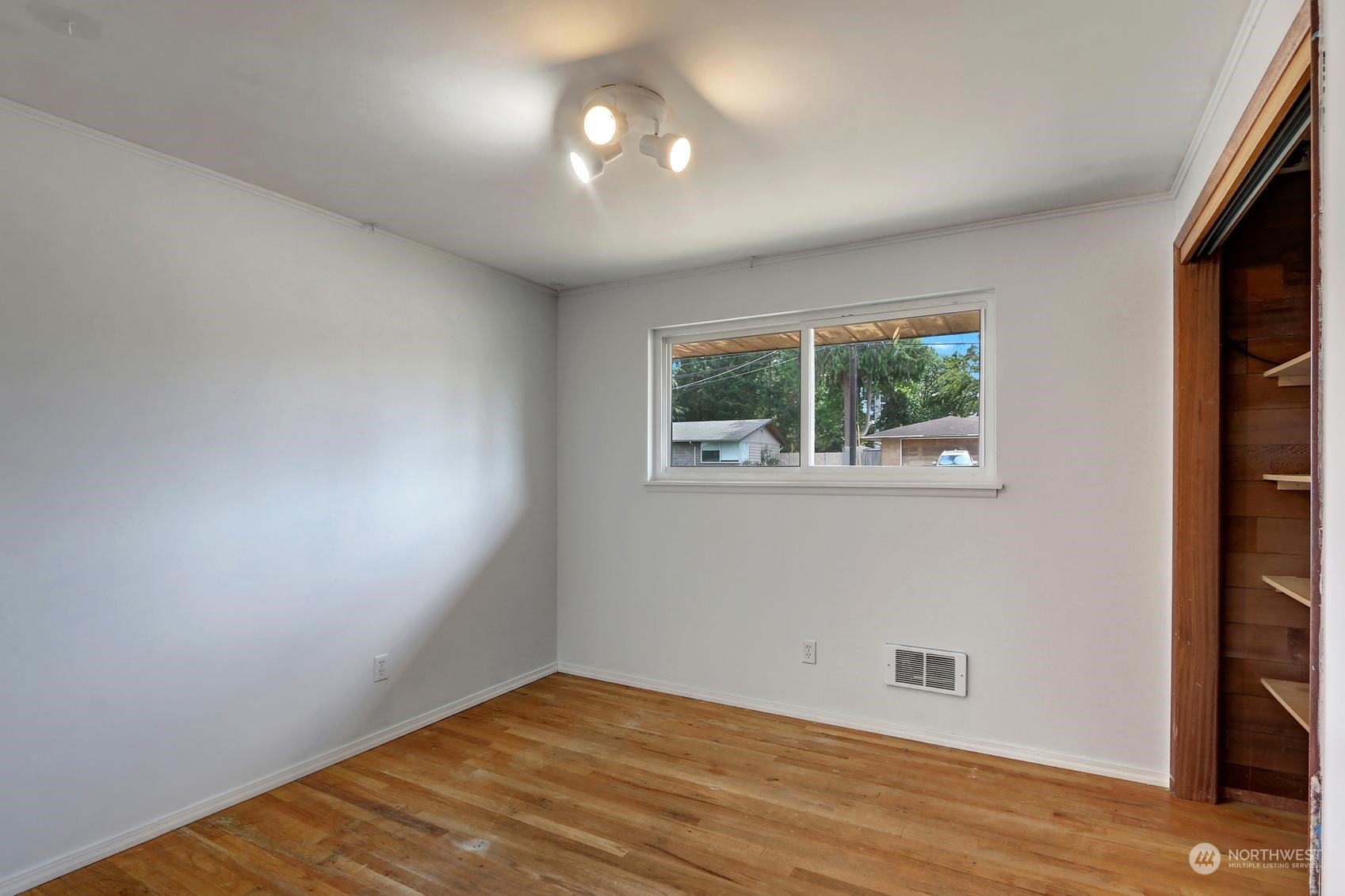 2303 Burley Drive Everett, WA 98208 - Photo 12 of 22 an empty room with wooden floor cabinet and windows