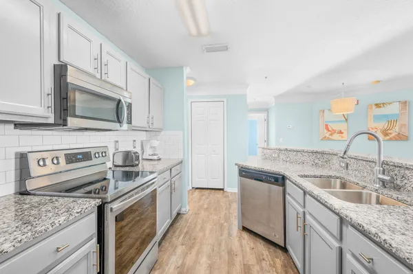 a kitchen with stainless steel appliances granite countertop a sink stove and refrigerator