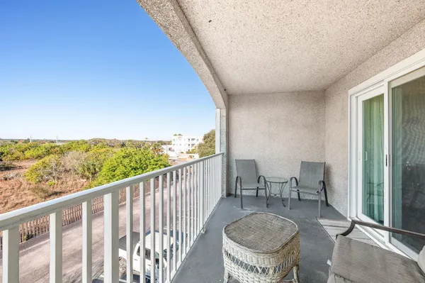 a view of a balcony with chairs and a floor to ceiling window