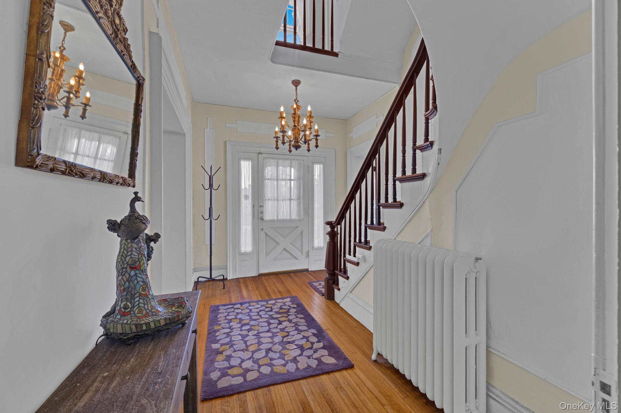 470 Little Britain Road Newburgh, NY 12550 - Photo 15 of 45 Entryway featuring radiator heating unit, hardwood / wood-style floors, and a chandelier