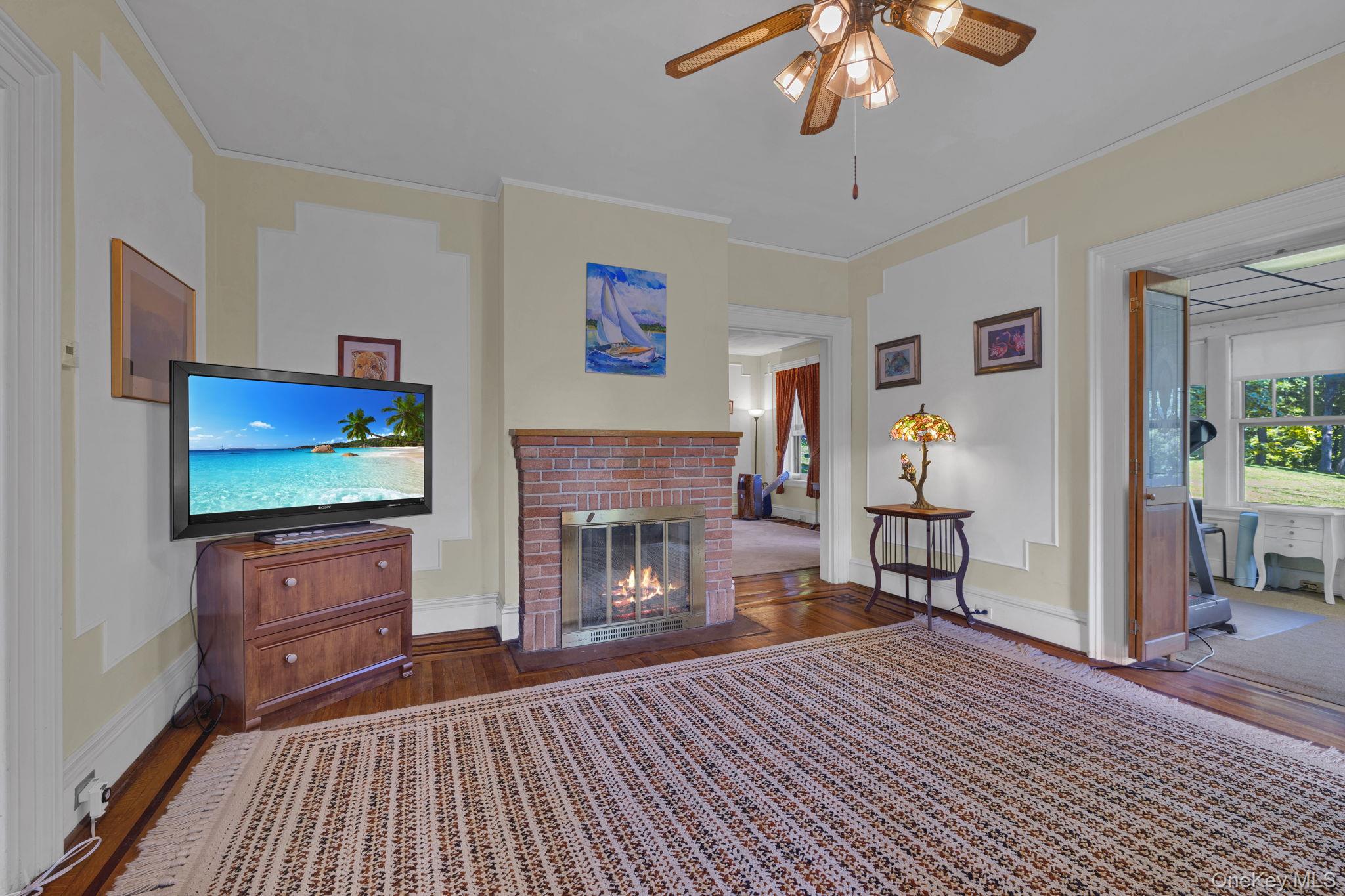 470 Little Britain Road Newburgh, NY 12550 - Photo 17 of 45 Living area with dark wood-type flooring, crown molding, ceiling fan, and a fireplace