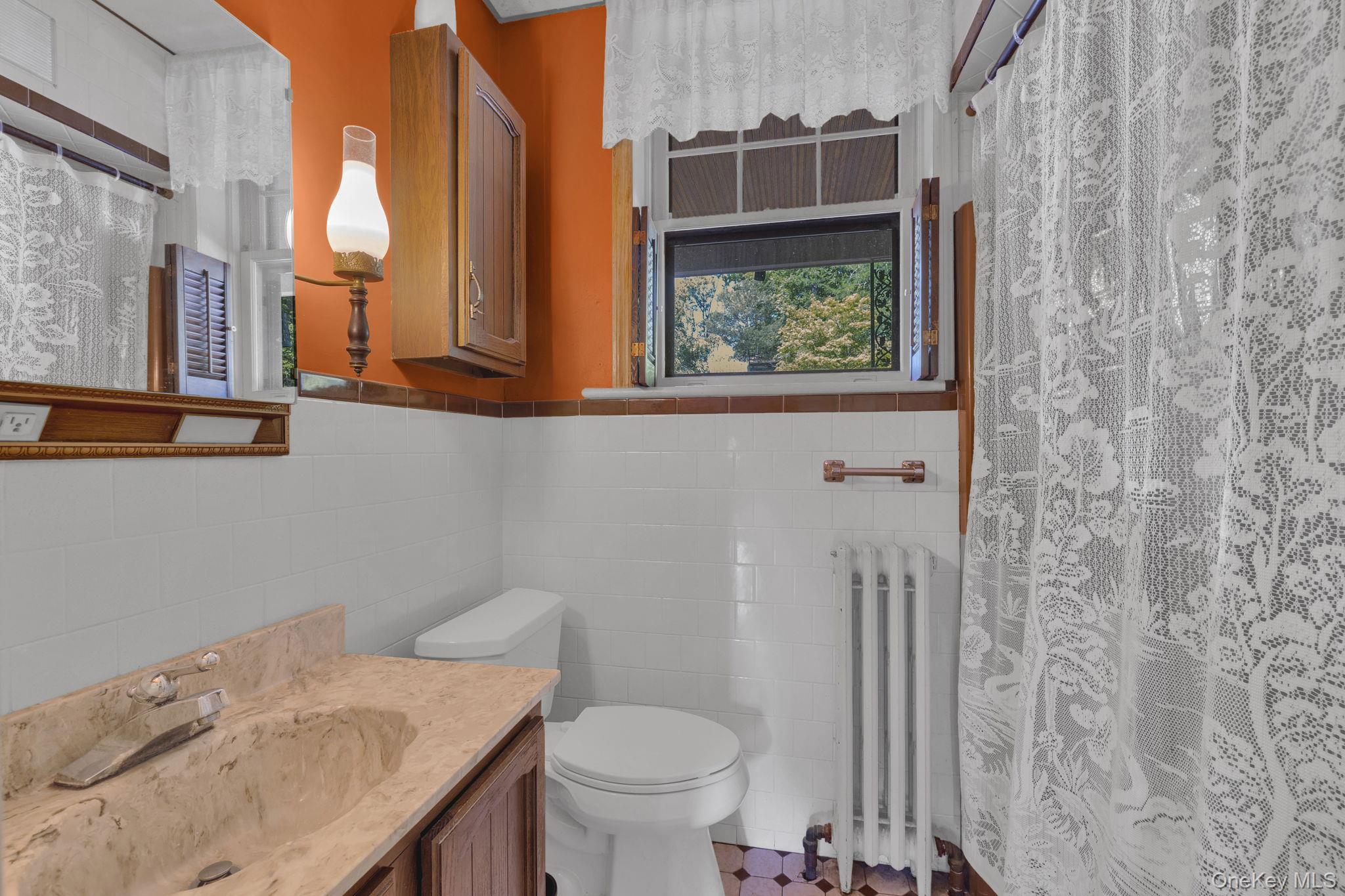 470 Little Britain Road Newburgh, NY 12550 - Photo 26 of 45 Bathroom featuring tile walls, radiator, vanity, a shower with shower curtain, and wainscoting