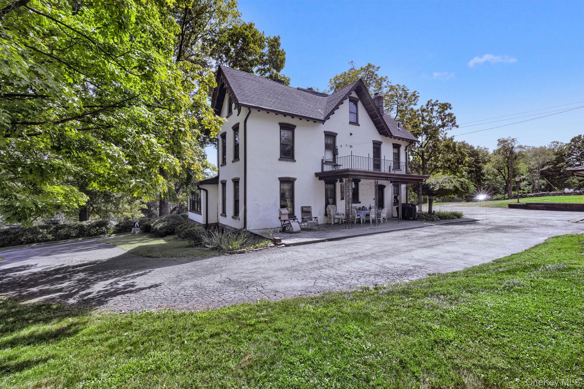 470 Little Britain Road Newburgh, NY 12550 - Photo 44 of 45 View of front of house with stucco siding, a balcony, a patio, a shingled roof, and a chimney