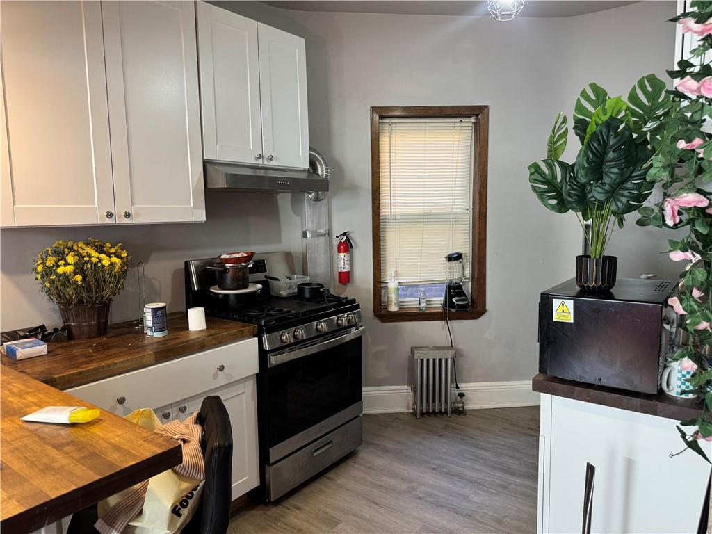 3112 Quentin Road Brooklyn, NY 11234 - Photo 3 of 6 a kitchen with stainless steel appliances a stove a refrigerator wooden floor and cabinets