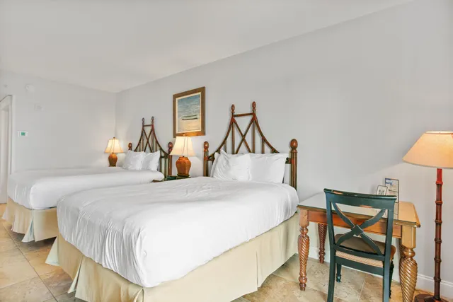 a bedroom with a bed and a potted plant on the dresser