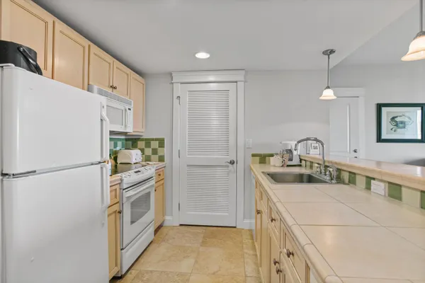 a kitchen with white cabinets and refrigerator