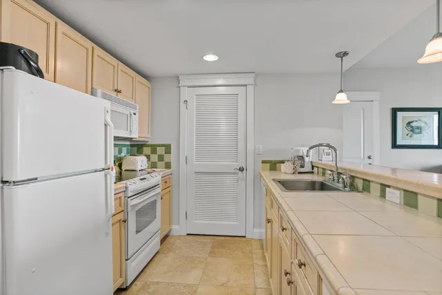 a kitchen with white cabinets and refrigerator