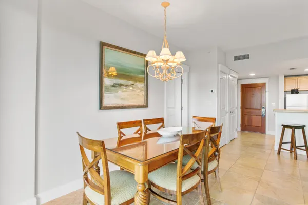 a dining room filled chandelier and wooden floor