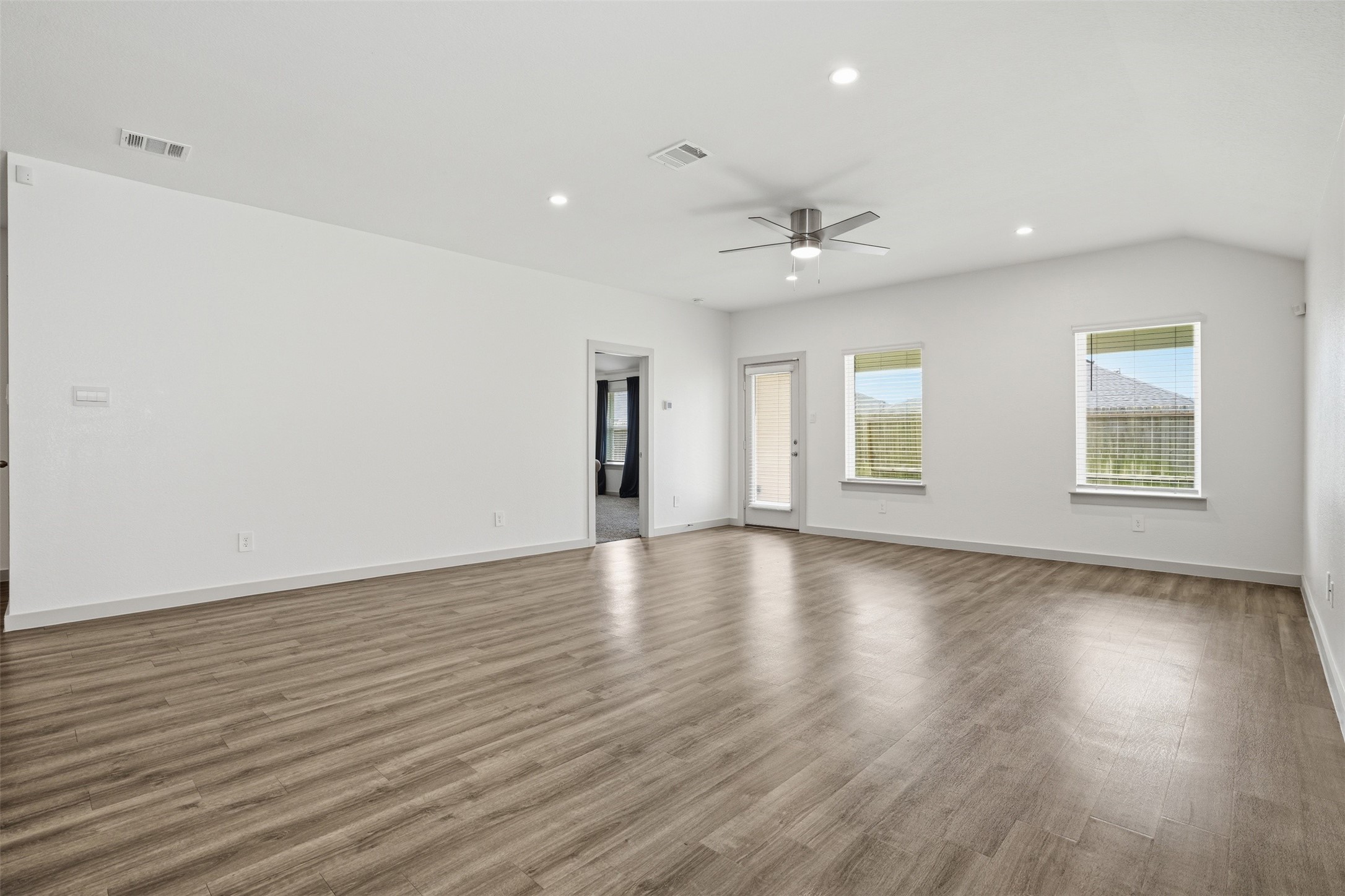 1022 Curly Angora Court Rosharon, TX 77583 - Photo 5 of 17 Luxury vinyl flooring paired with abundant natural light creates a bright, airy atmosphere throughout the main living area.